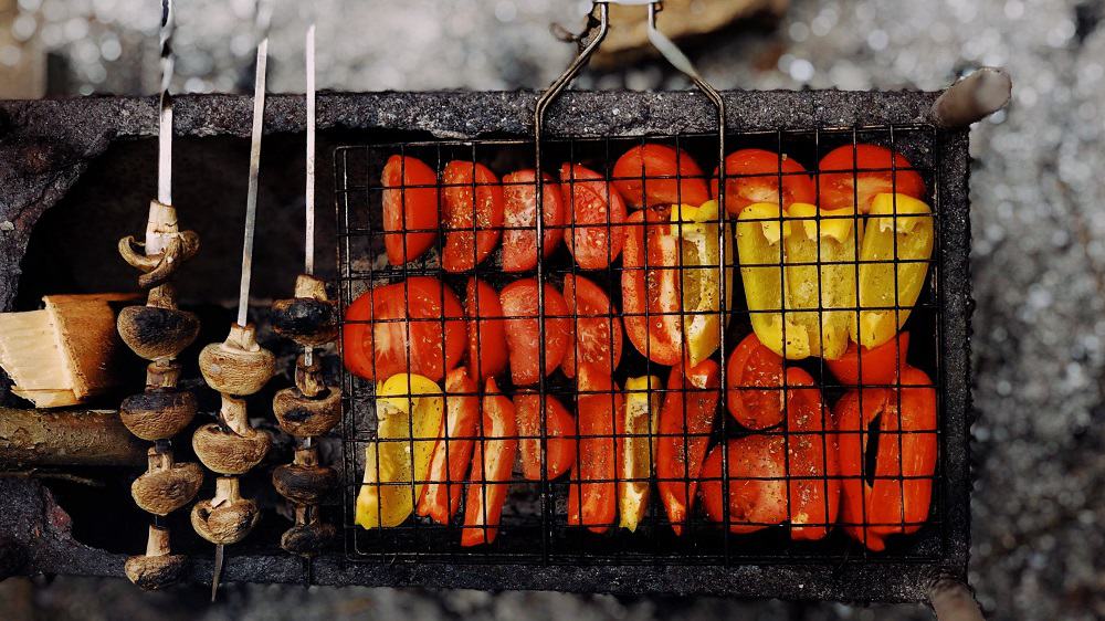 Barbecue met rode en gele paprika, tomaat en champignons