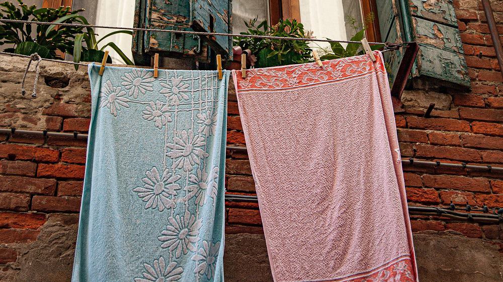 Blauwe en roze handdoek aan de waslijn