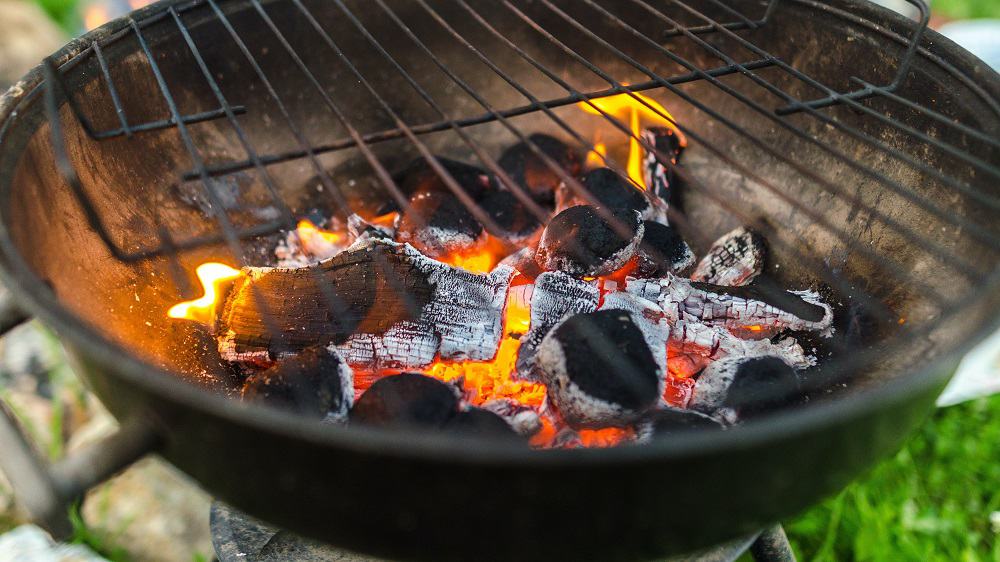 Barbecue met gloeiende kolen onder het rooster