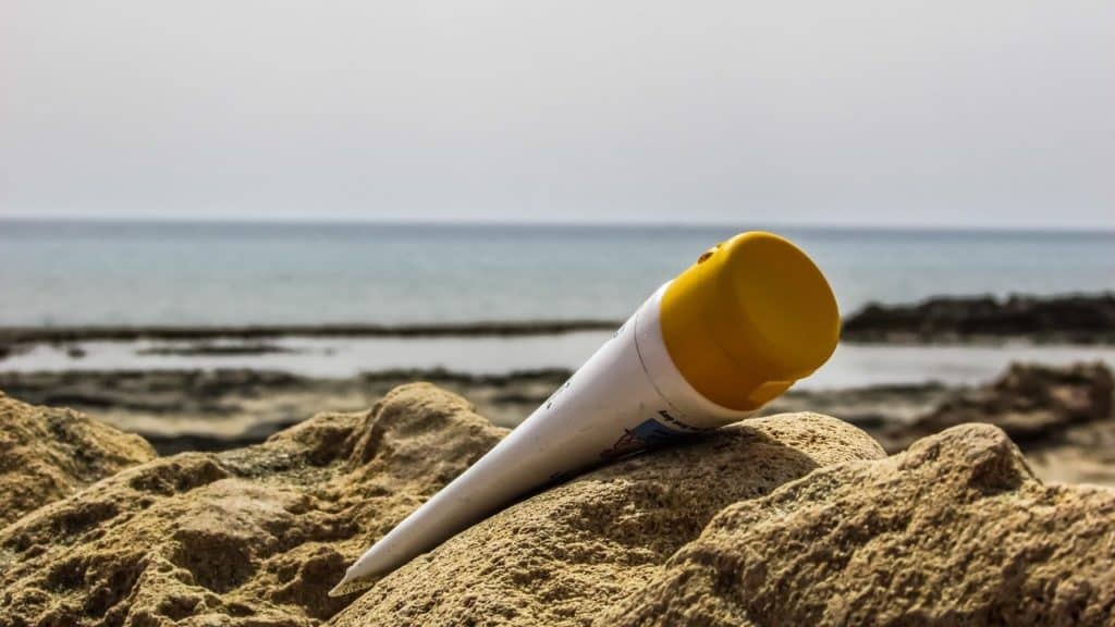 zonnebrand fles op strand met zee