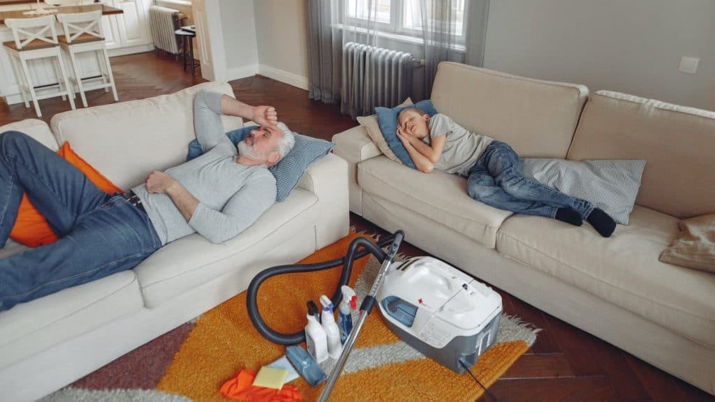 Mensen liggen op de bank met het stoomapparaat ernaast op de grond