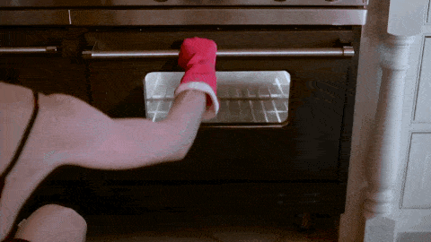 Oven wordt geopend met handschoen