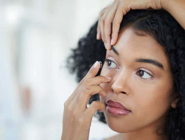 Vrouw doet contactlens in