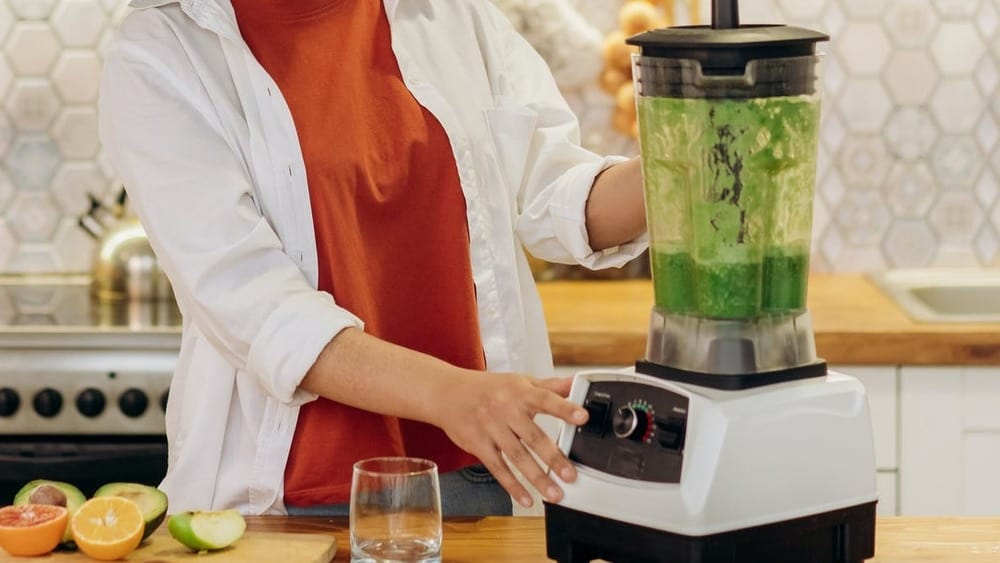 Vrouw zet een blender aan