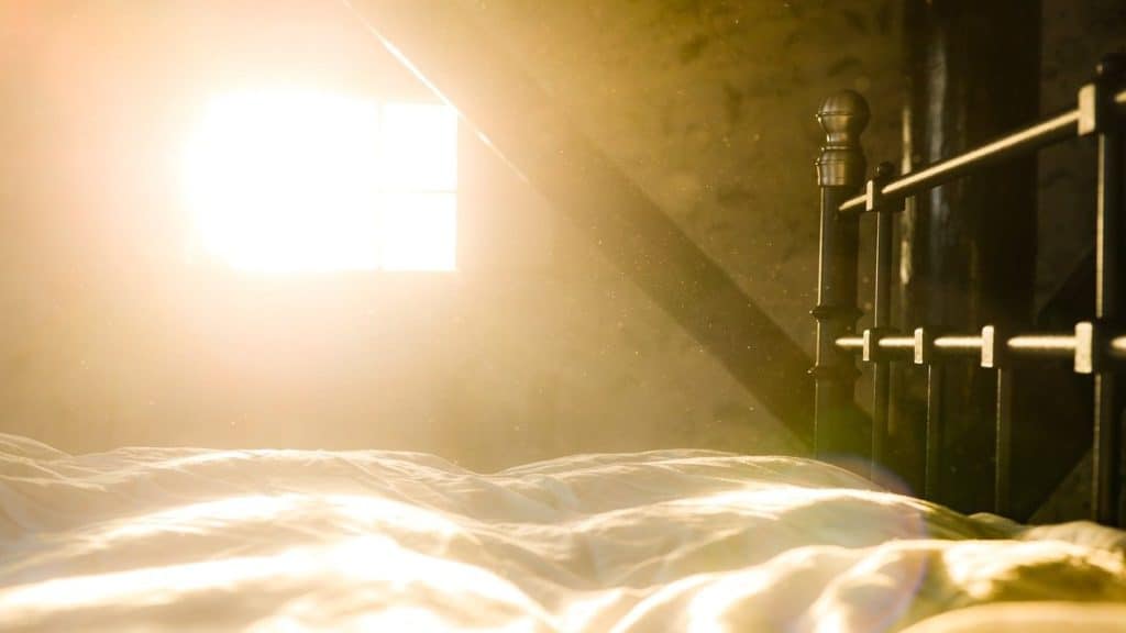 felle warme zon schijnt naar binnen door raam op bed