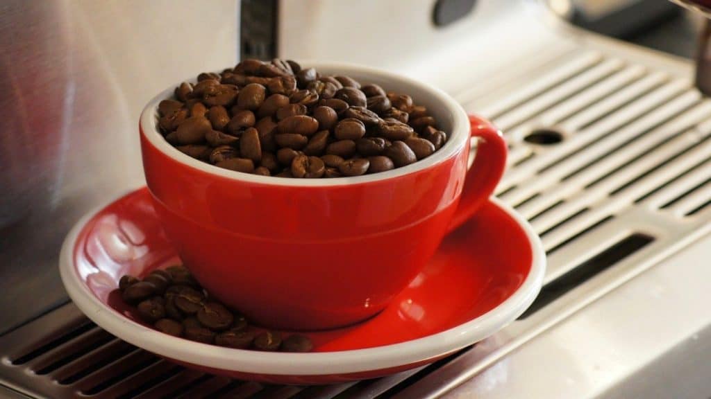 rood koffie kopje gevuld met koffiebonen