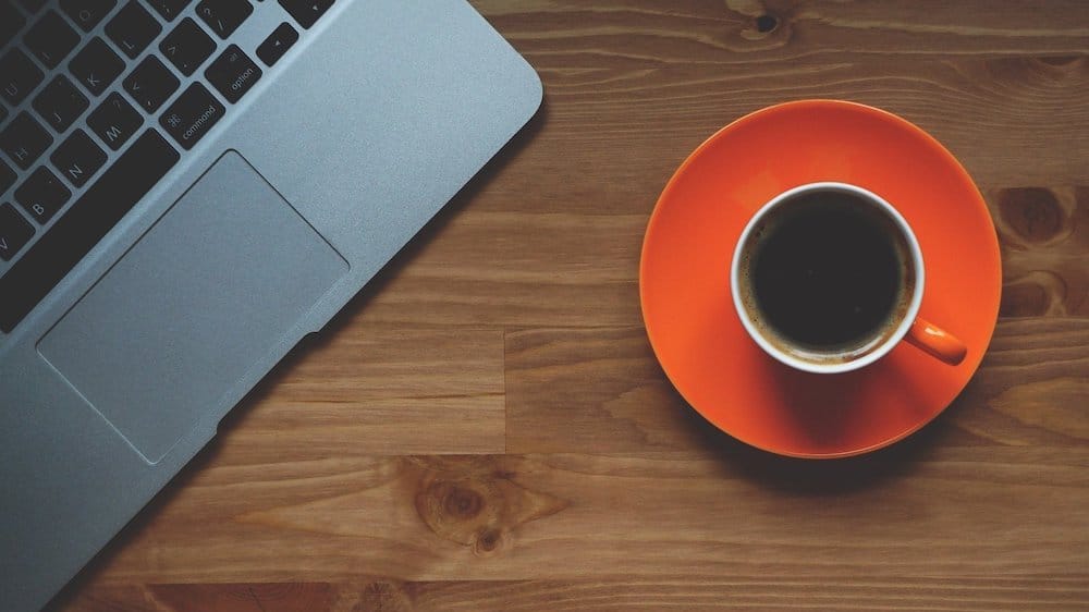 kopje zwarte koffie naast laptop