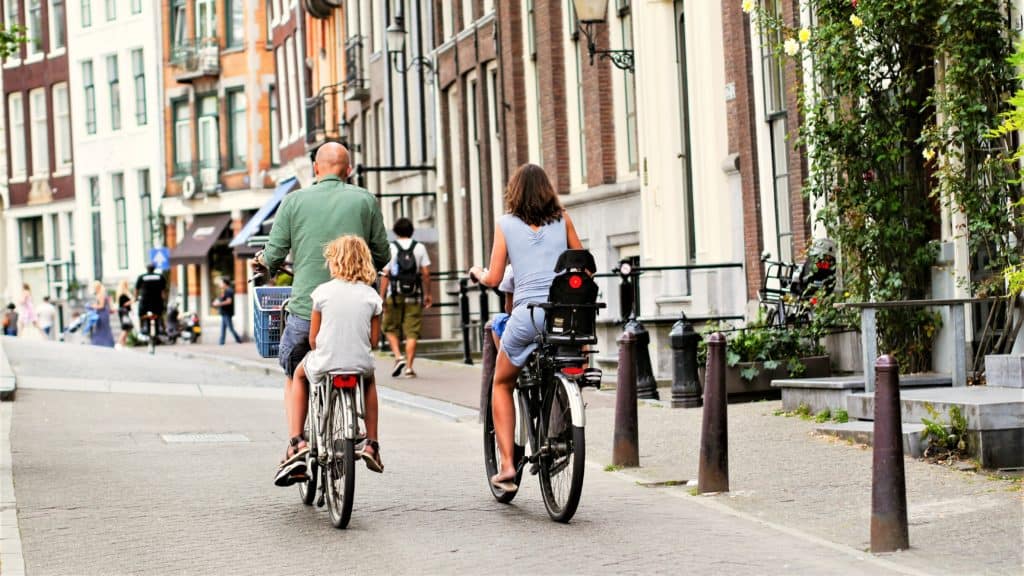 Ouders die fietsen met hun kinderen op de fiets.