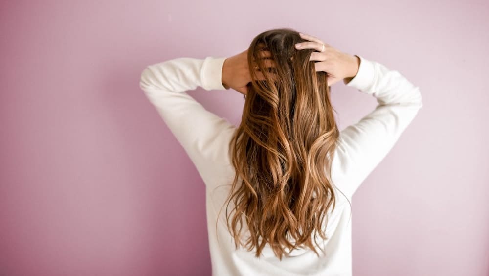 vrouw met handen in golvend haar