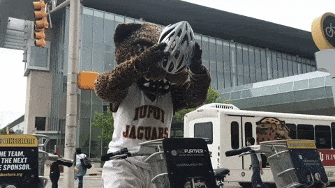 Een mascotte zet een fietshelm op