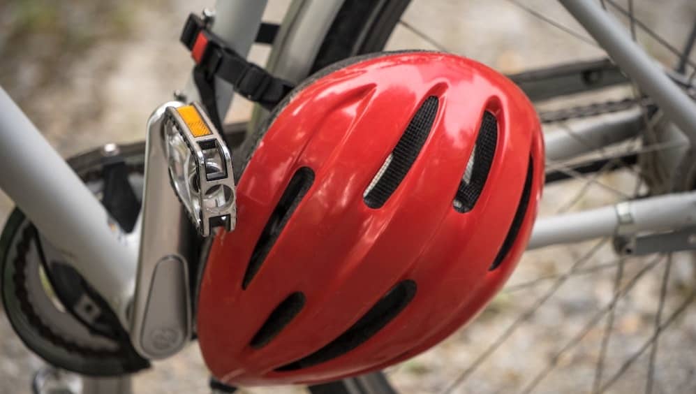 rode fietshelm vastgemaakt aan fietswiel