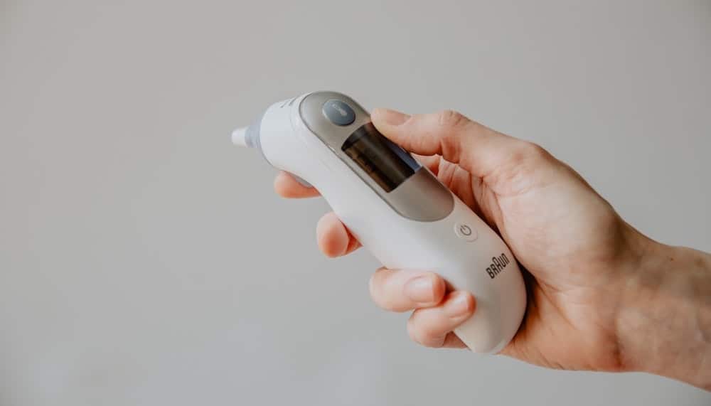 hand houdt oorthermometer vast
