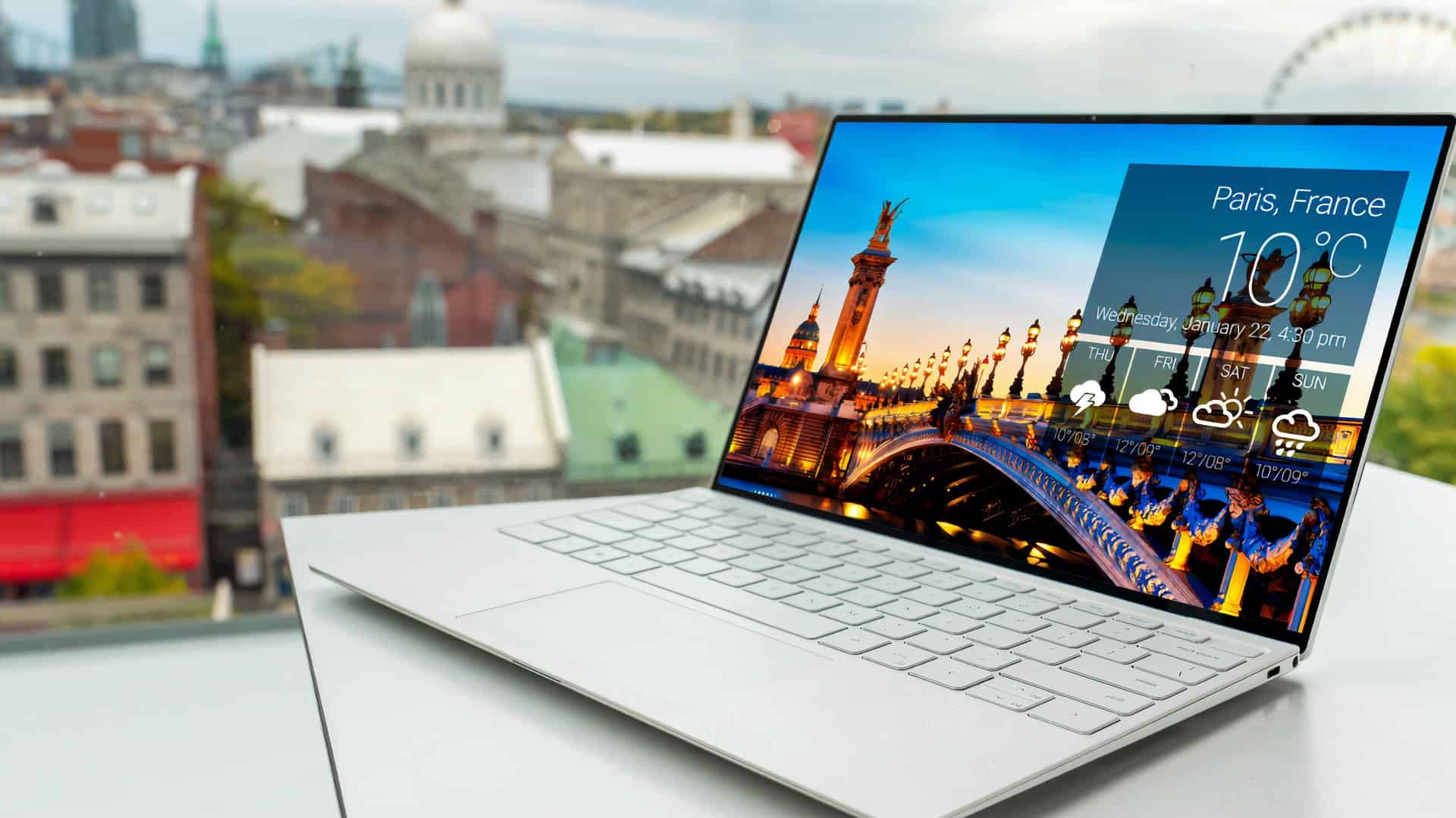 Laptop met Parijs op het scherm. Er is een stedelijke achtergrond. 