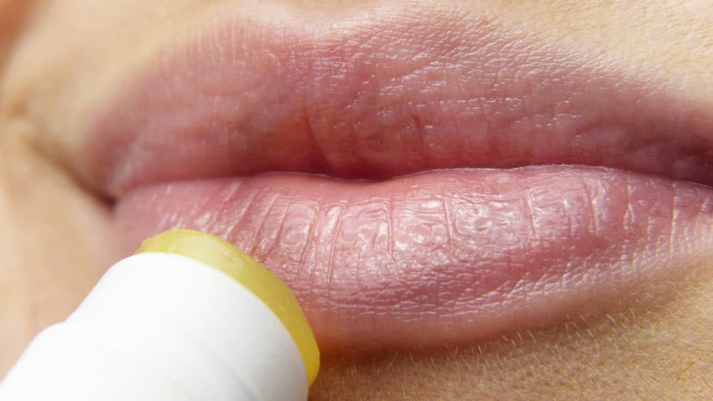 droge lippen waar lippenbalsem op wordt aangebracht