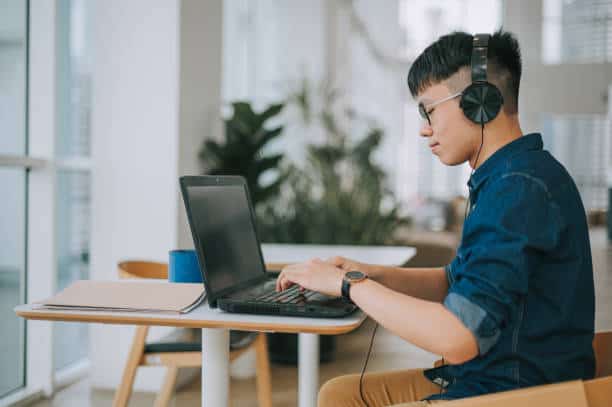 man werkt achter laptop
