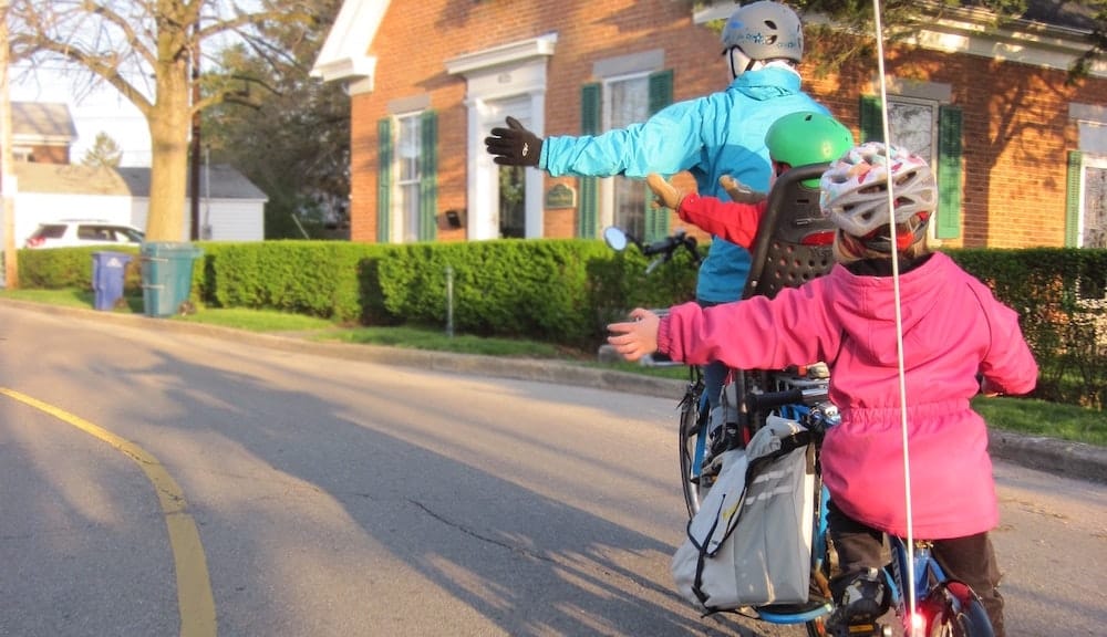 ouder fietsend met twee kinderen