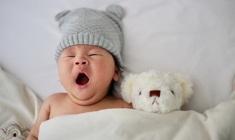 gapende baby met teddybeer