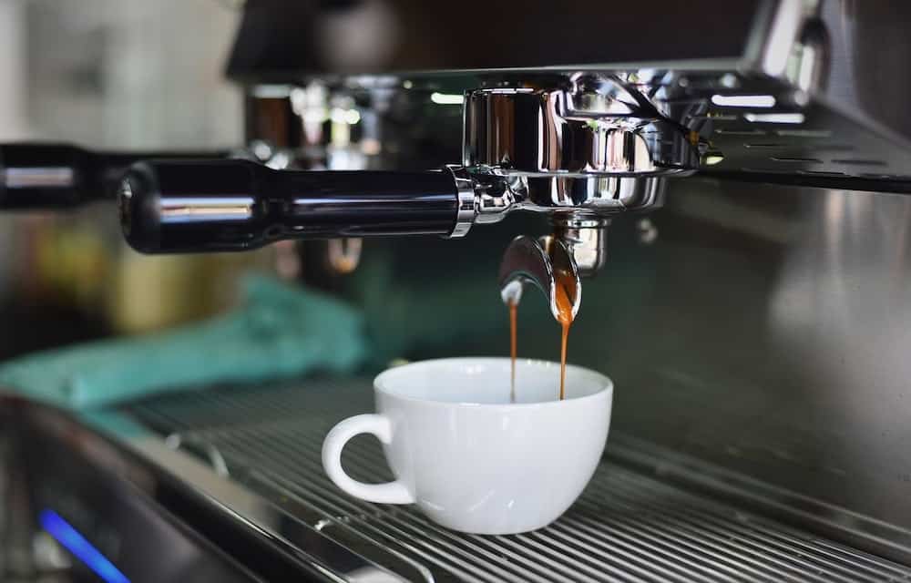 kopje koffie onder koffiezetapparaat