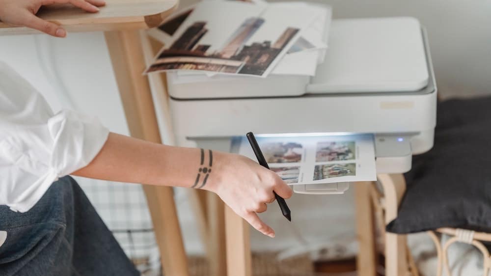 vrouw haalt afdrukken uit witte printer