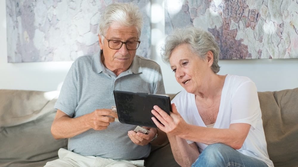 twee senioren houden tablet vast