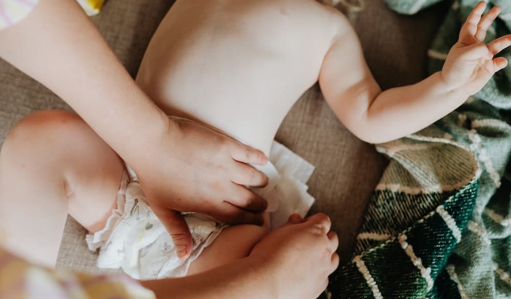 vrouw die luier van baby vervangt