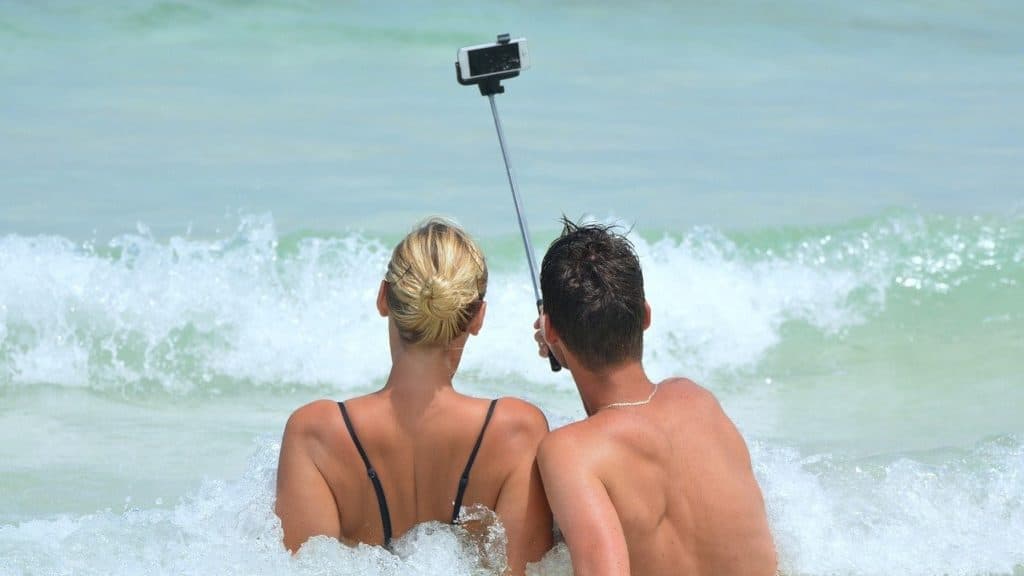 twee mensen maken een selfie met de selfie stick in de zee
