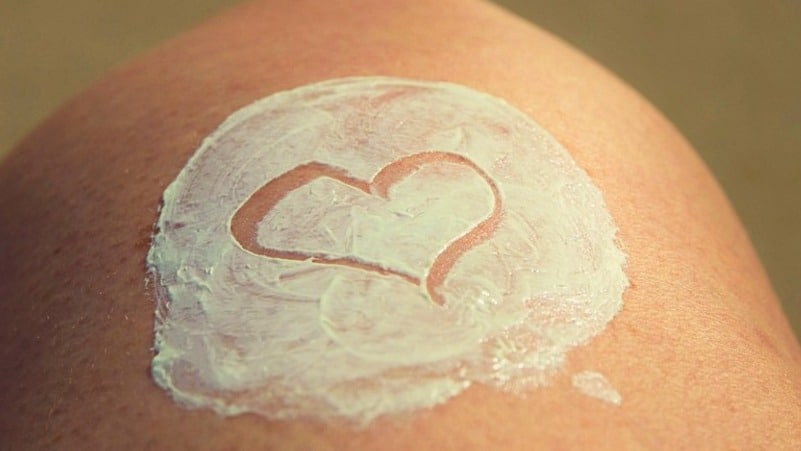 Crème die op de huid gesmeerd is, met een hartje erin getekend.