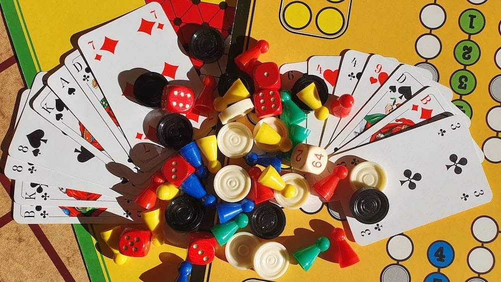 speelkaarten, pionnen en damstenen op een bordspel