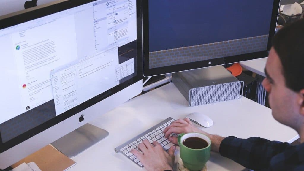 persoon typt achter beeldscherm desktop