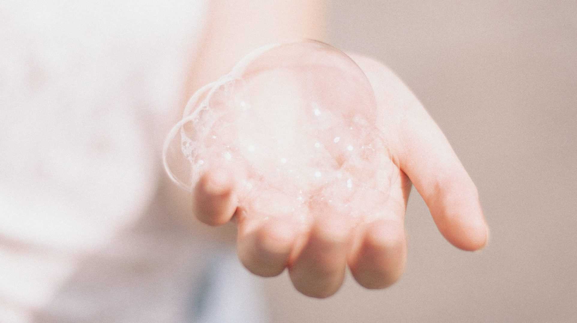 hand houdt gezichtsreiniger bubbel in hand