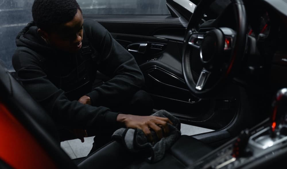 man maakt auto interieur schoon