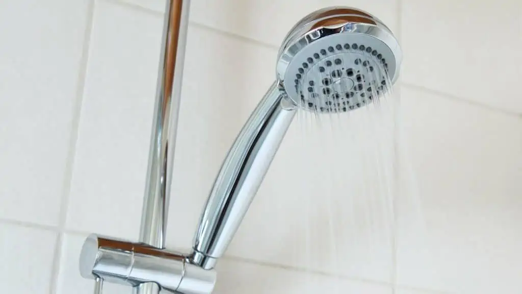 douchekop staat aan in witte badkamer