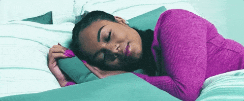 Vrouw met paarse trui slaap op blauw beddengoed