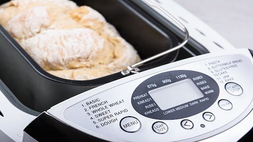 Vers brood in een broodbakmachine, waarbij het bedieningsscherm van de machine wordt getoond.