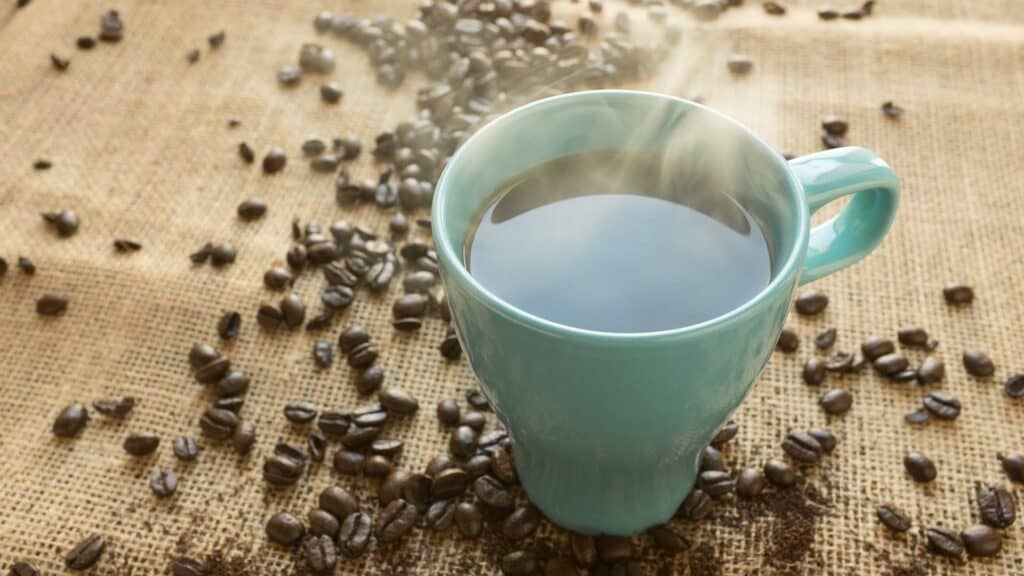 Vers kopje koffie omringd met koffiebonen