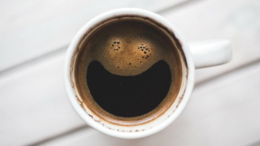 Kopje koffie met afdruk van lachend gezichtje