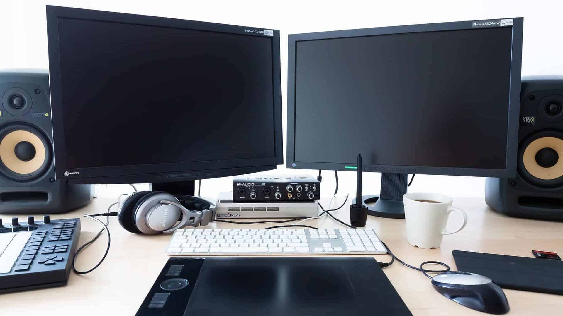 Symmetrische pc-setup met twee monitoren, twee pc-speakers een toetsenbord en trackpad