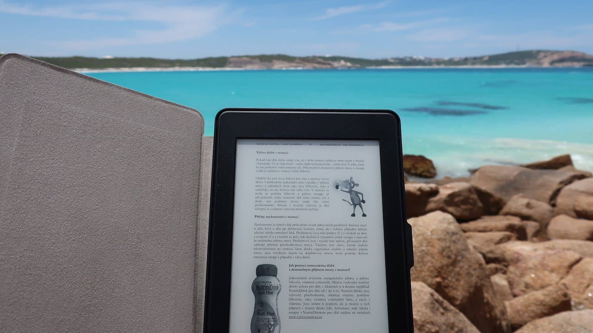 E-reader bij een blauwe zee