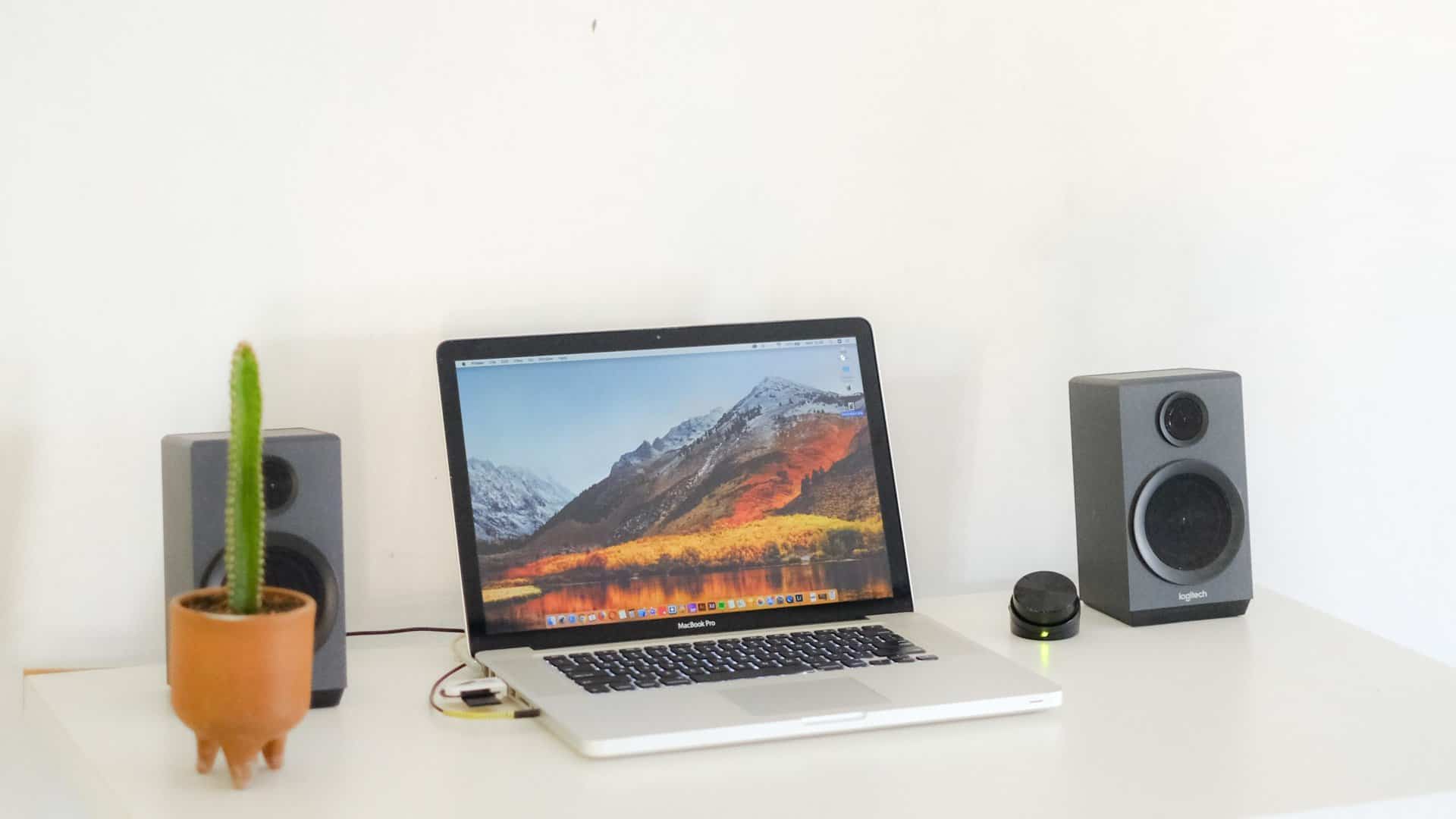 Laptop met aangesloten pc-speakers op een wit bureau