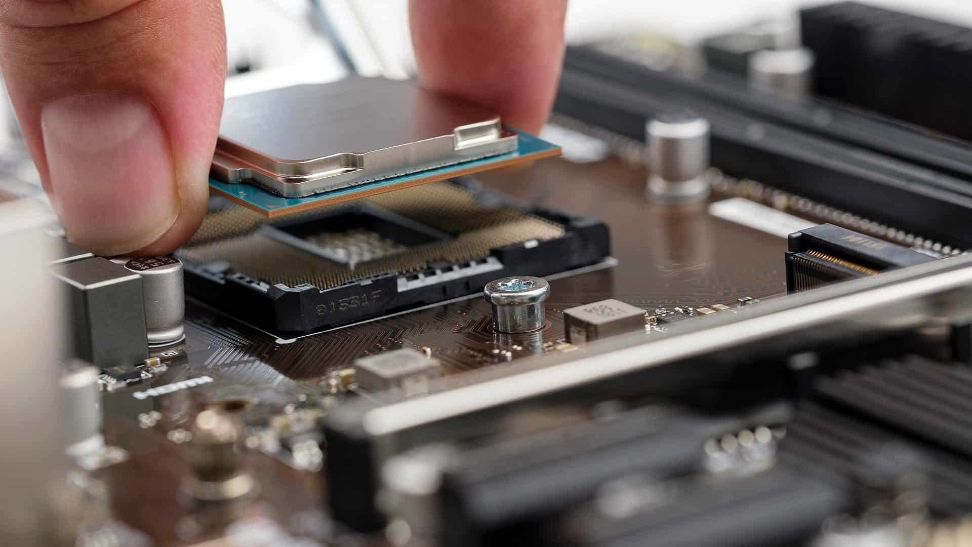 Close up van vingertoppen die een 
processor-chip in laptop installeren. 