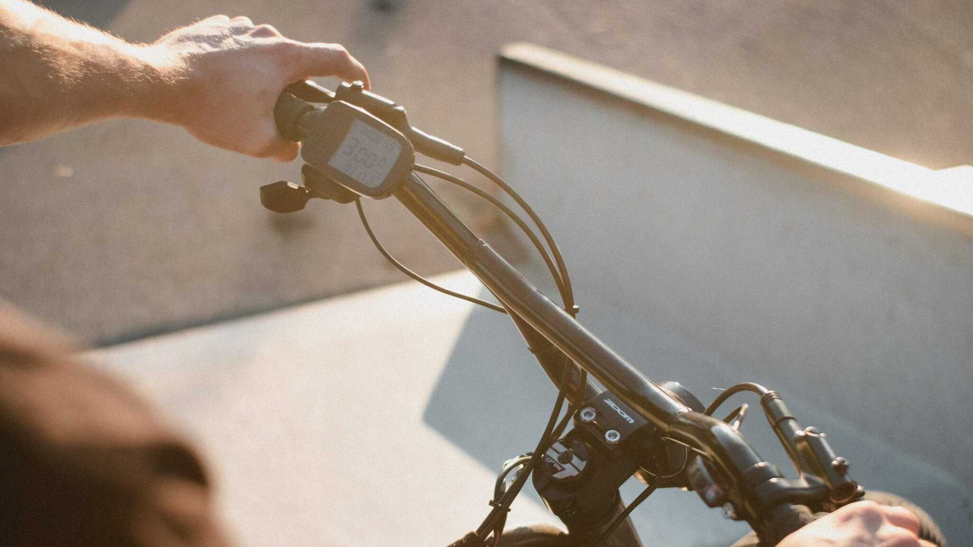 Man houdt stuur vast van e-bike met fietscomputer